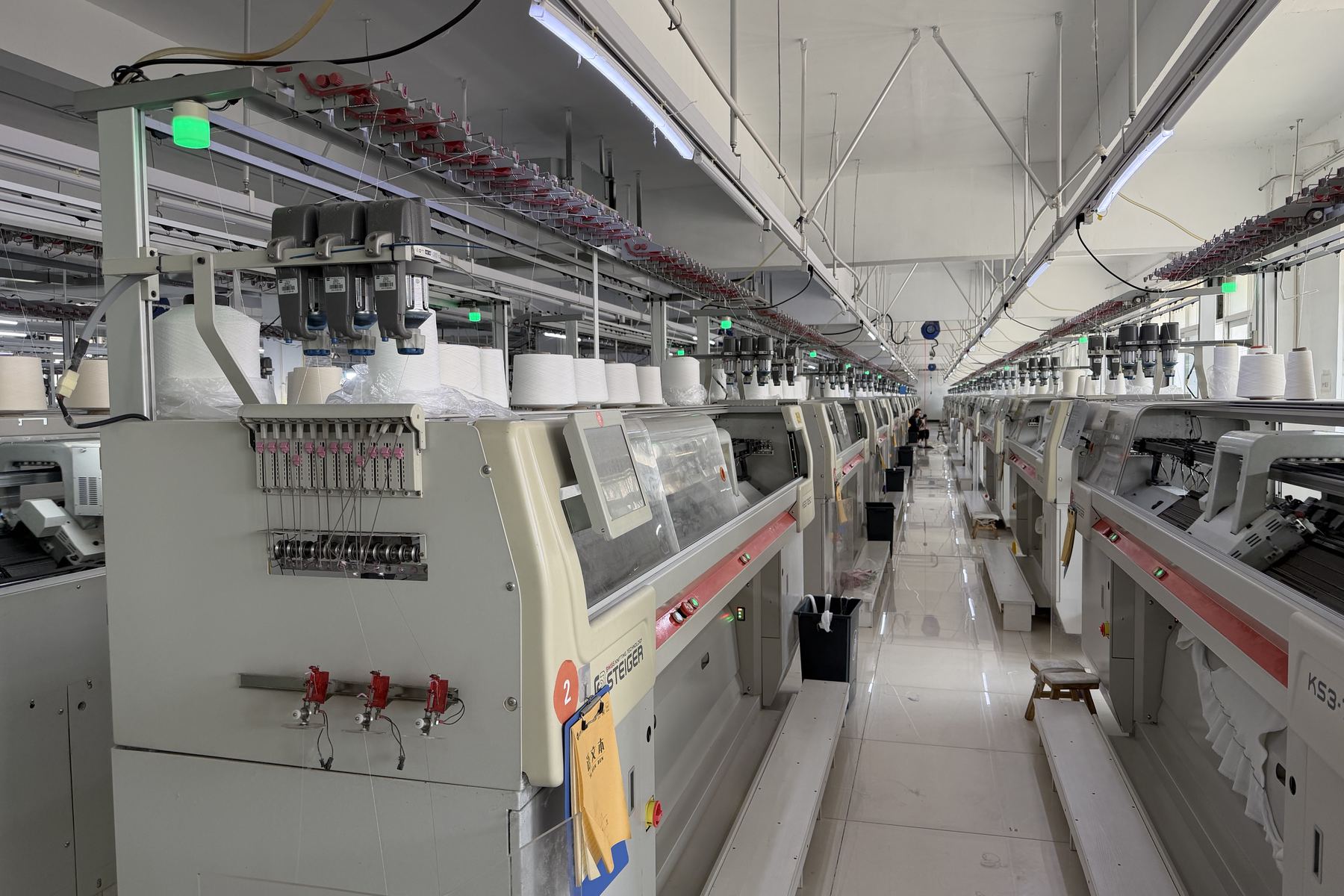 Computerized flat knitting machines running in a partner factory